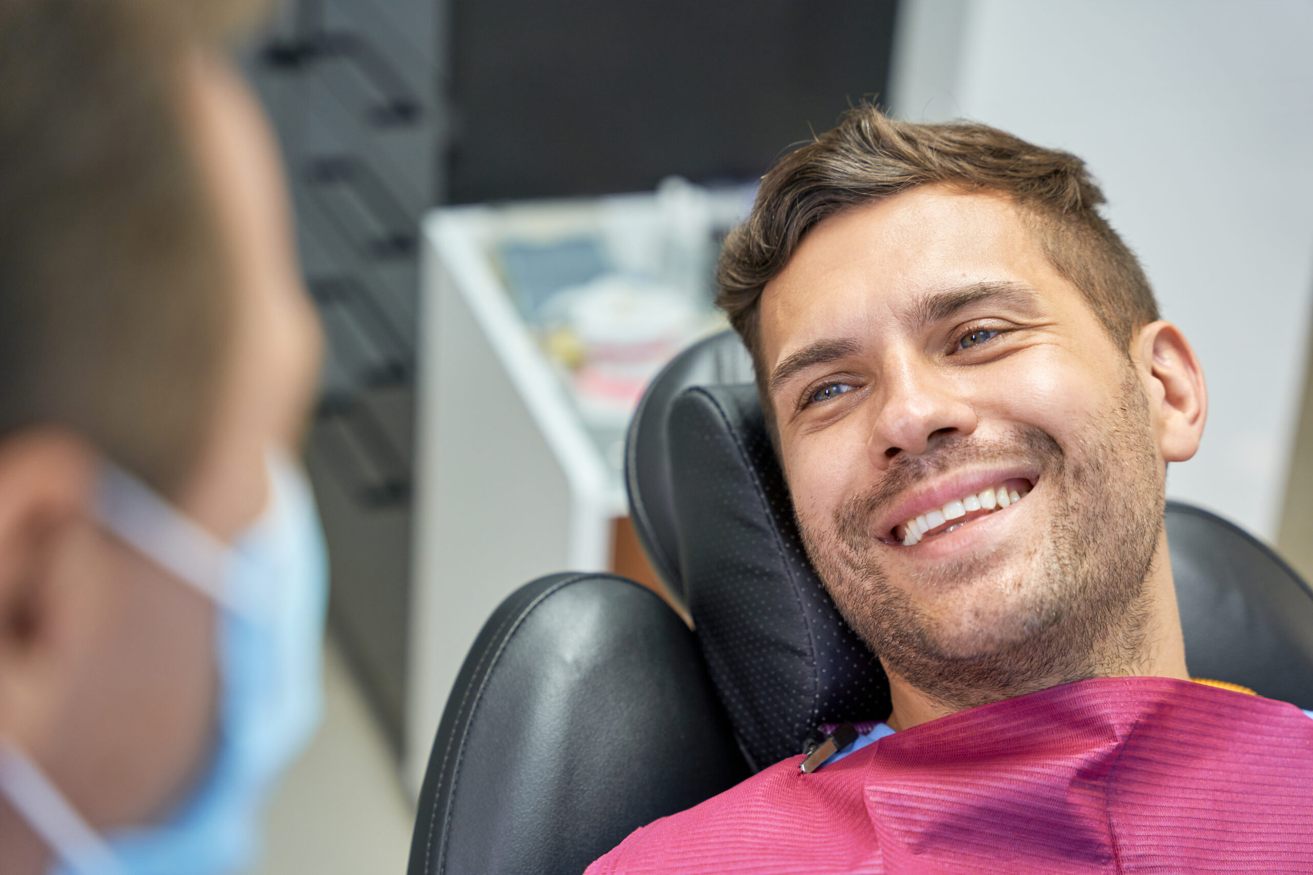 smiling man sitting calmly in a dental chair, sedation dentistry
